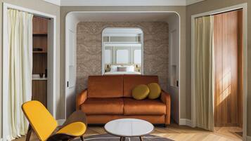 A modern living room with a sofa, two chairs, a small table, and a window.