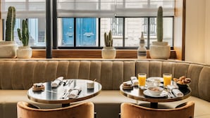 A dining area with two round tables, cushioned seating, and potted cacti. - Pavillon Faubourg Saint-Germain & Spa (Paris)