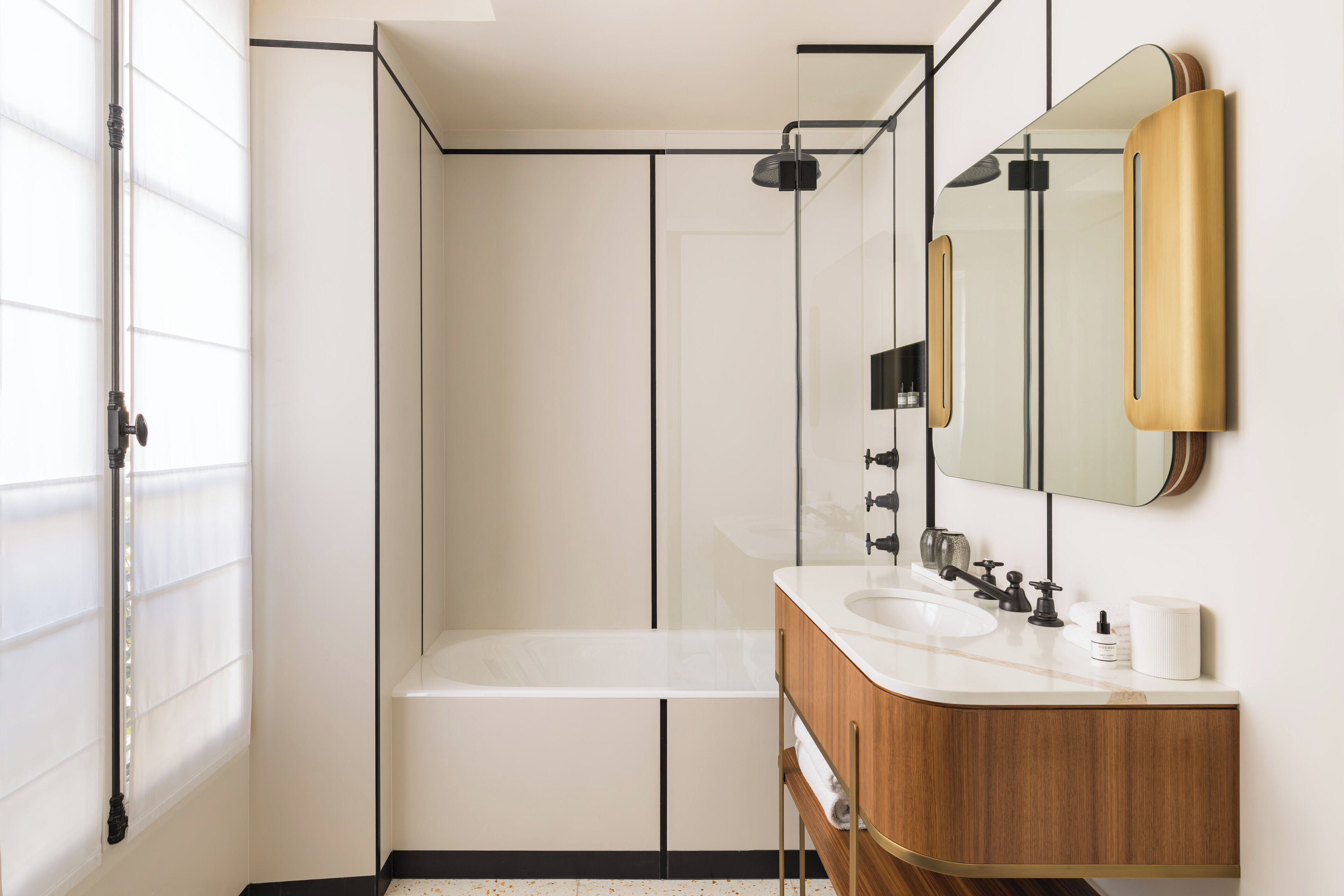 A modern bathroom with a bathtub, a double sink vanity, and a large mirror.