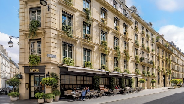 A classic Parisian building with outdoor seating, large windows, and decorative plants. - Pavillon Faubourg Saint-Germain & Spa (Paris)