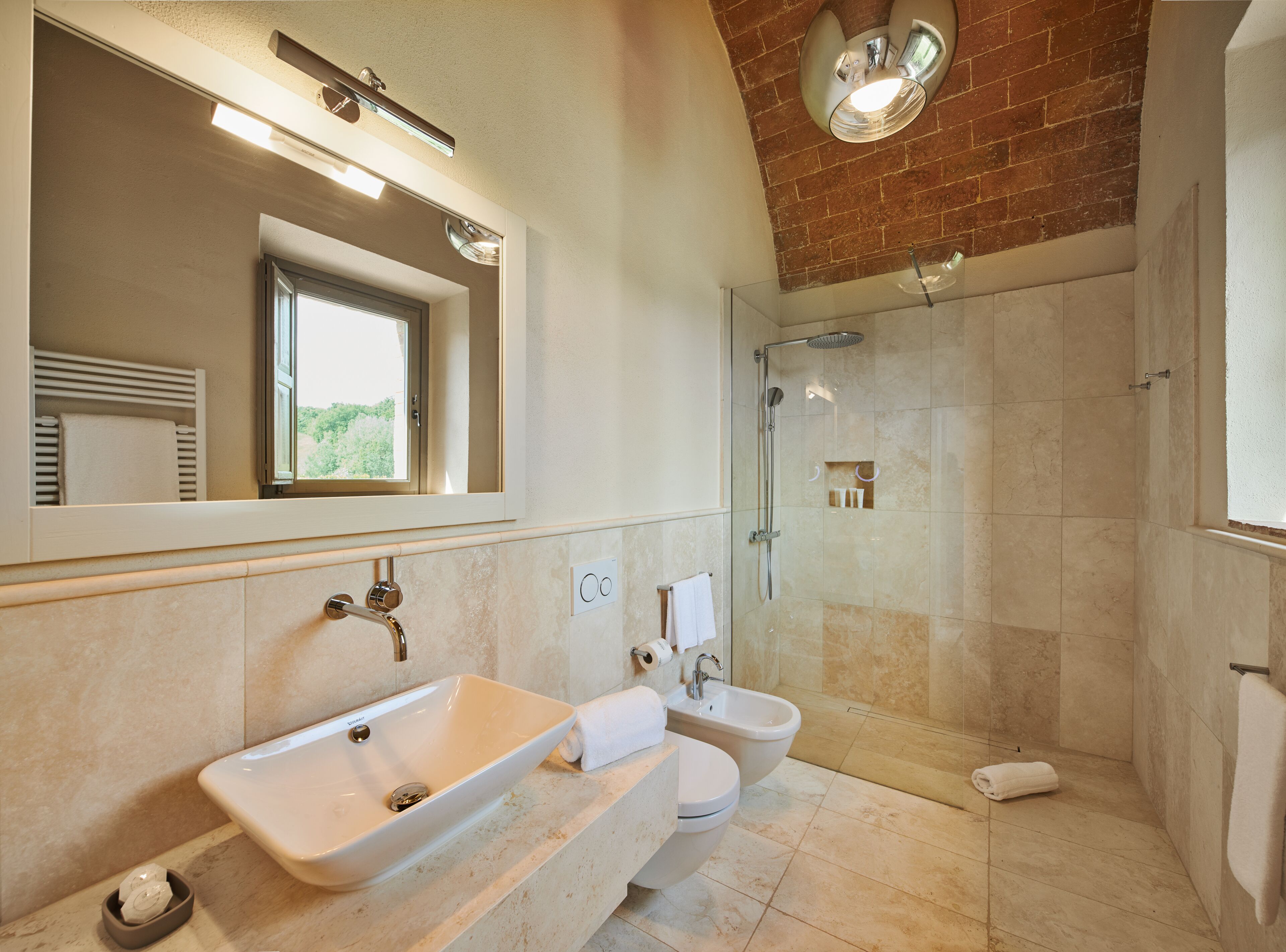 A modern bathroom with a large mirror, a sink, a toilet, and a shower area.