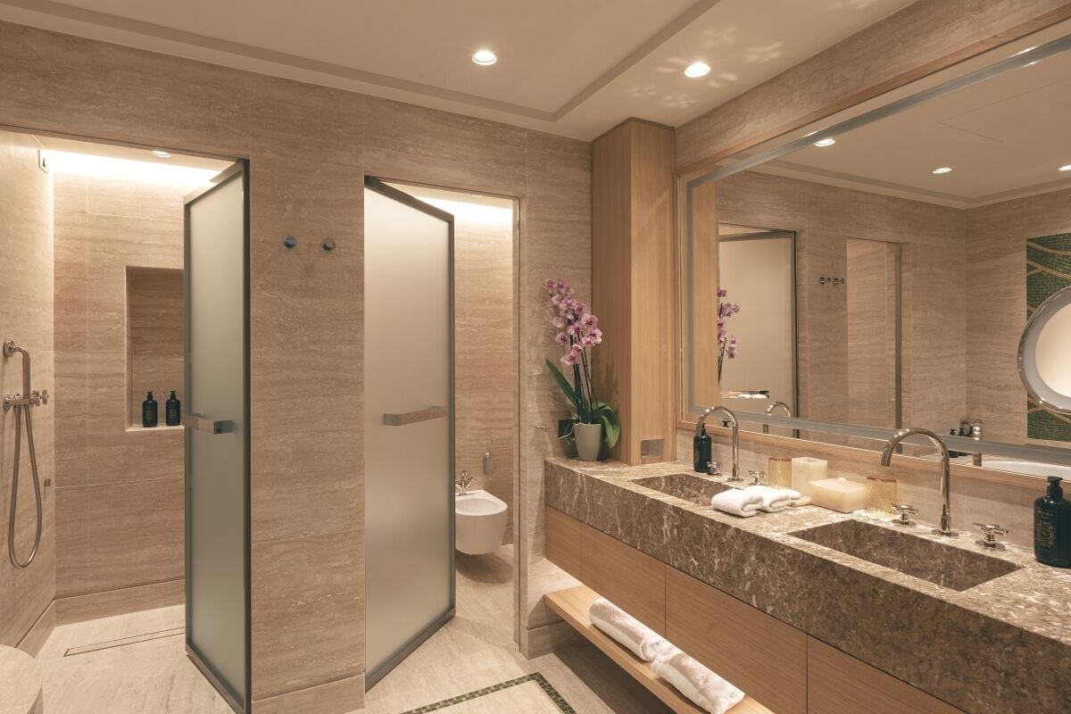 A modern bathroom with a walk-in shower, a vanity with a large mirror, and a sink.