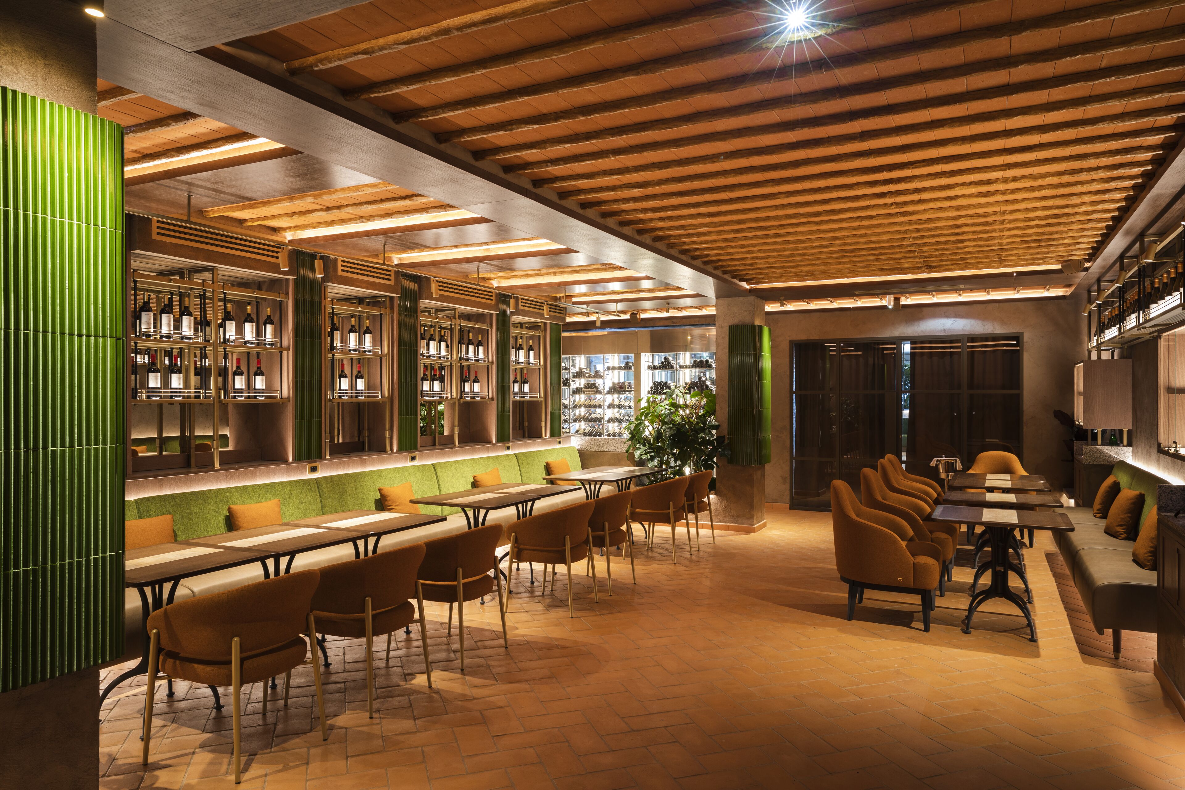 A modern restaurant with wooden beams, green accents, and a variety of seating options.