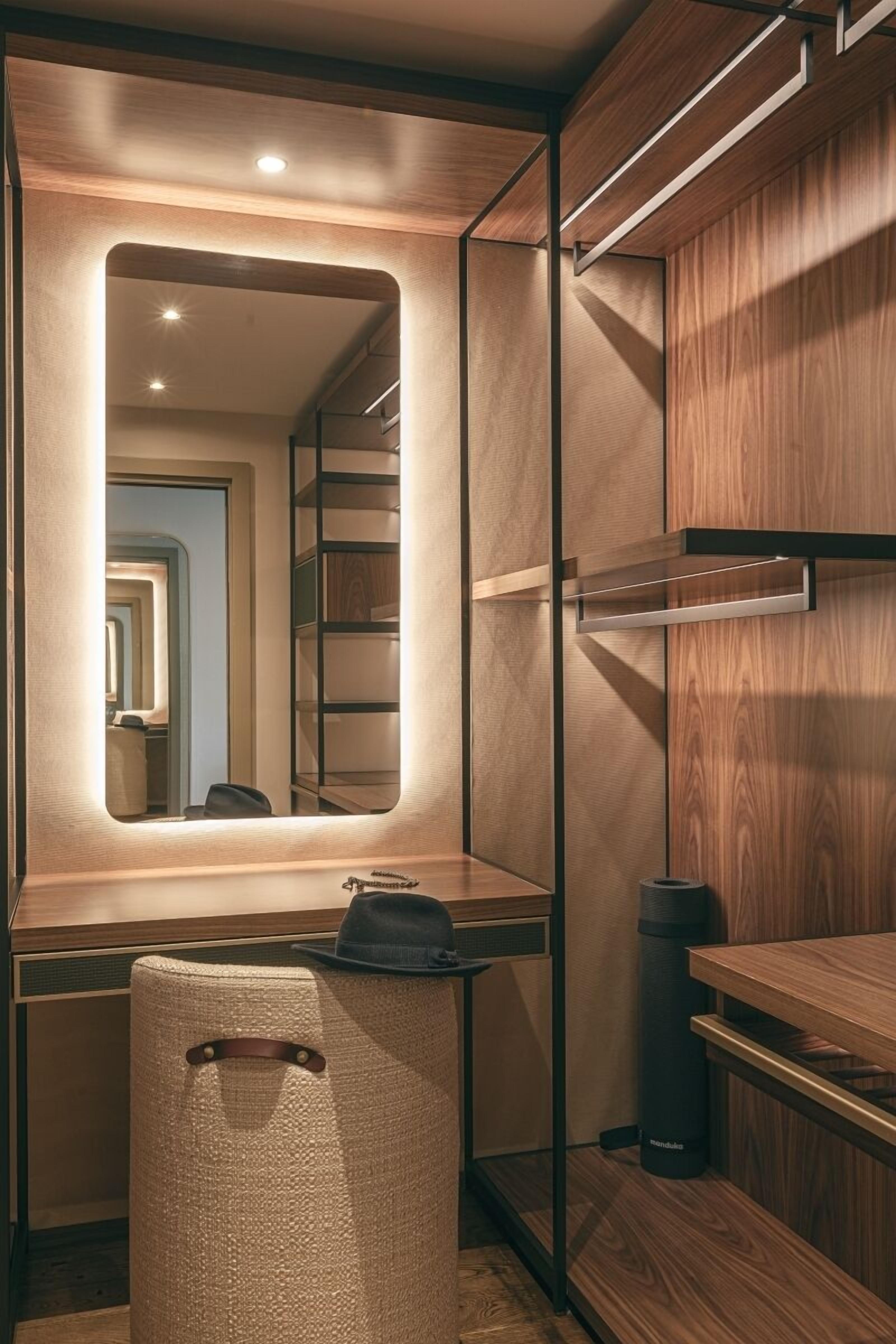 A modern bathroom with a wooden vanity, a mirror, and a towel rack.