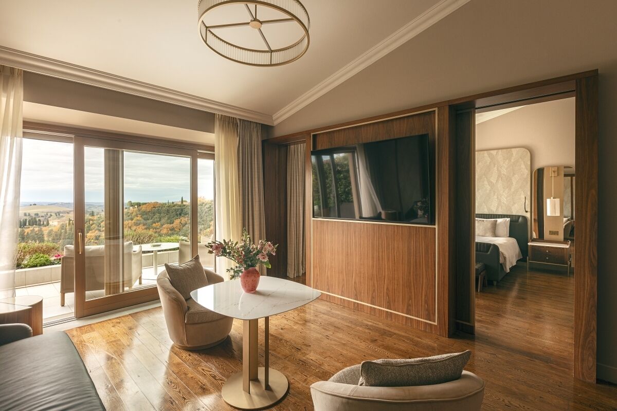 Une chambre d’hôtel moderne avec un balcon, une table ronde et un lit.