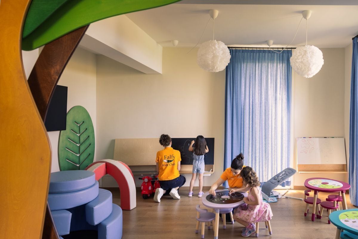 A children's playroom with colorful furniture, a blackboard, and a whiteboard.