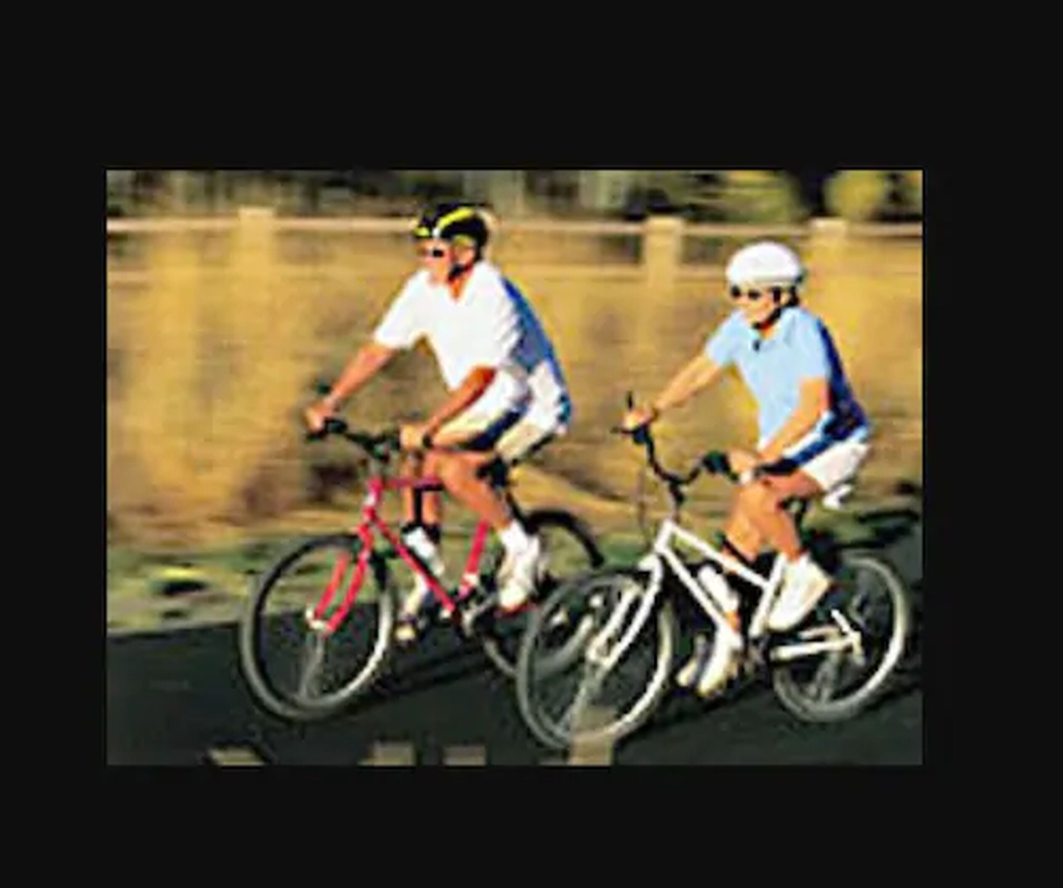 Duas pessoas andando de bicicleta numa estrada.
