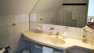 Un baño moderno con un lavabo grande, un perchero para toallas y un espejo.