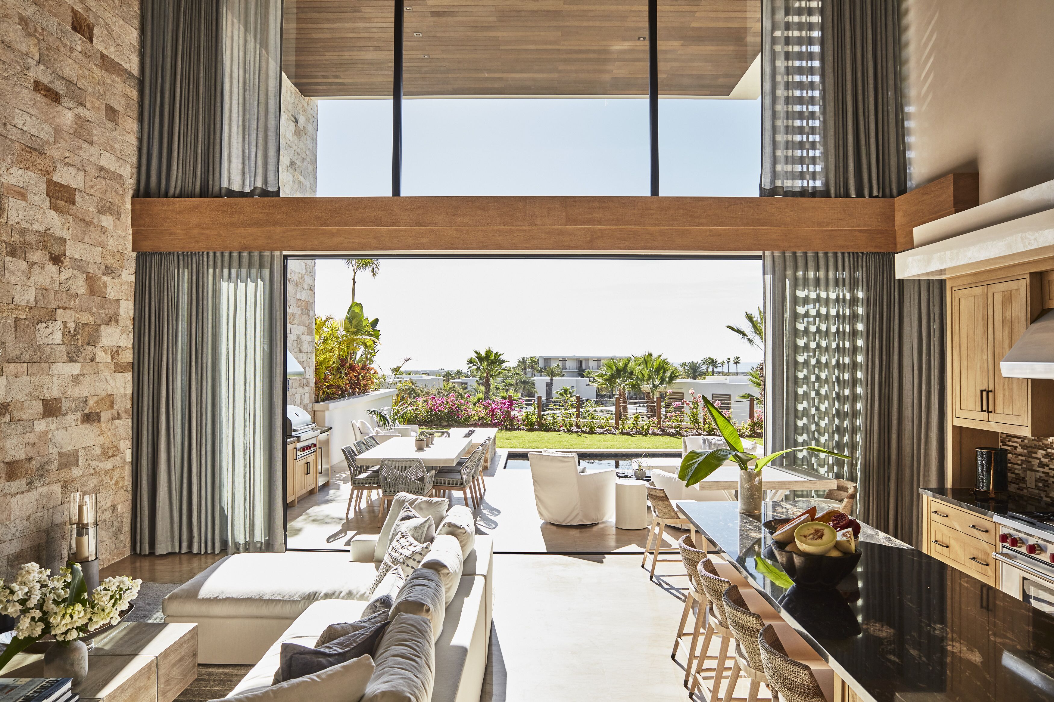 A modern kitchen with a large island, a dining area with outdoor seating, and a view of the cityscape.