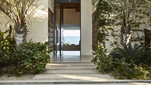 A pathway leading to a balcony with a view of the sea, surrounded by tropical plants and a modern architectural design. - Chileno Bay Resort & Residences, Auberge Collection (Cabo San Lucas)