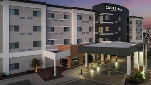 Un hôtel moderne doté d’une cour intérieure, de plusieurs étages et d’une enseigne bien visible indiquant « Courtyard by Marriott ».