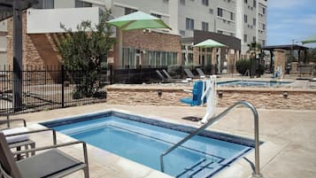 Una piscina al aire libre, tumbonas