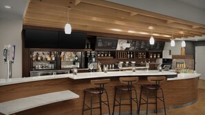 Un espace bar moderne avec un comptoir en bois, des tabourets de bar et un présentoir pour le menu.