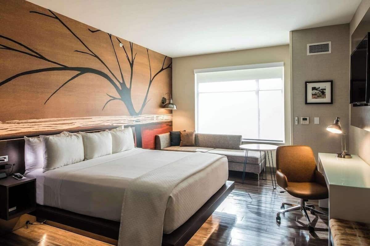 Escritorio, cortinas blackout y tabla de planchar con plancha