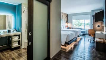 Una habitación de hotel con cama, mesita de noche y ventana.