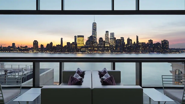 A modern interior with a view of a city skyline at sunset.
