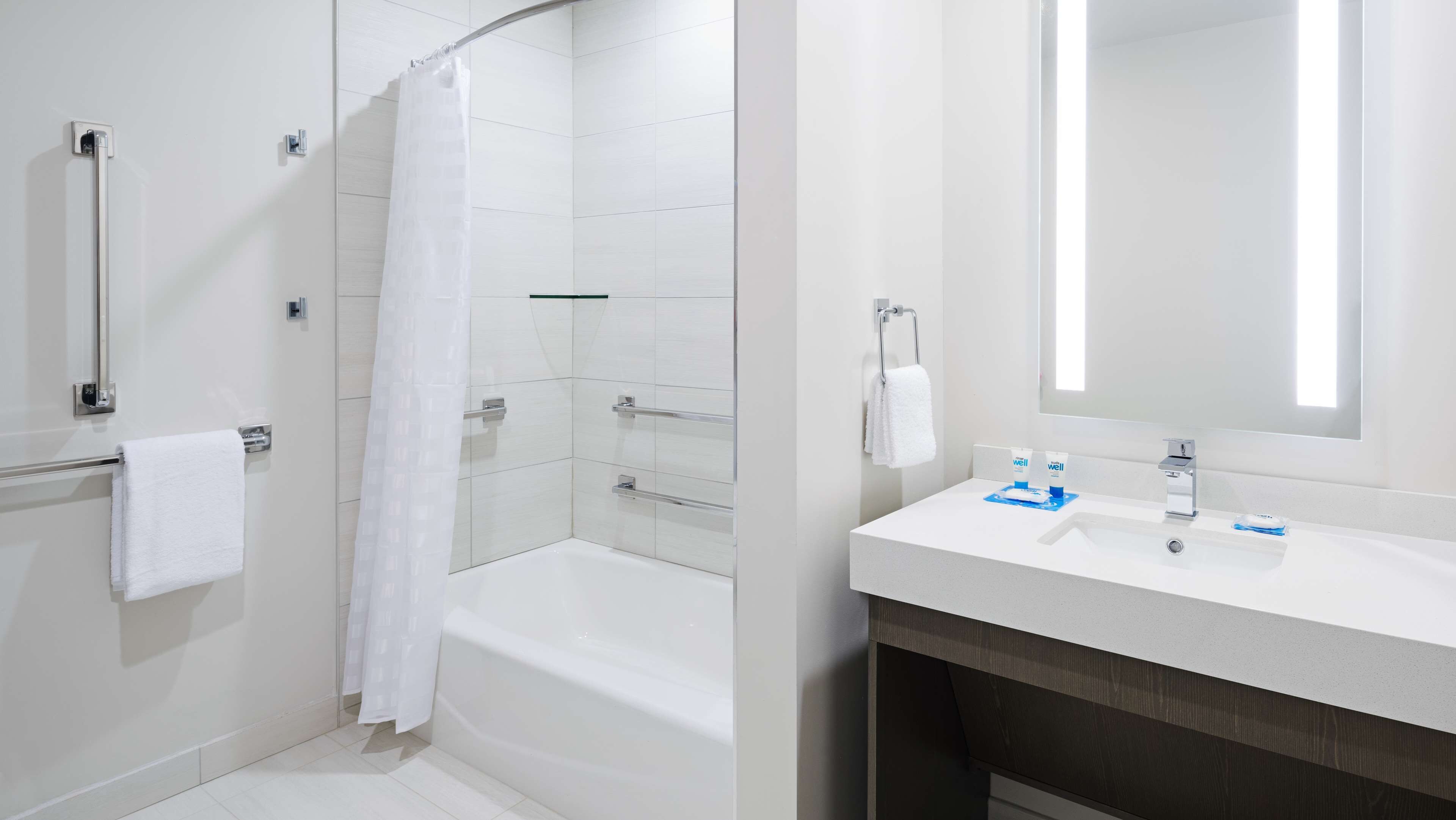 A modern bathroom with a walk-in shower, a bathtub, and a vanity with a large mirror.