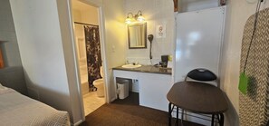 A bathroom with a toilet, sink, mirror, and a hairdryer. - Fairview Inn (Fairview)
