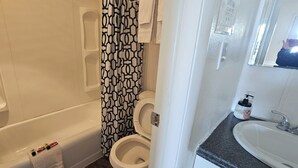 A bathroom with a bathtub, toilet, and a sink.