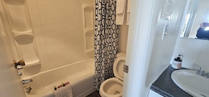 A bathroom with a bathtub, toilet, and a sink. - Fairview Inn (Fairview)