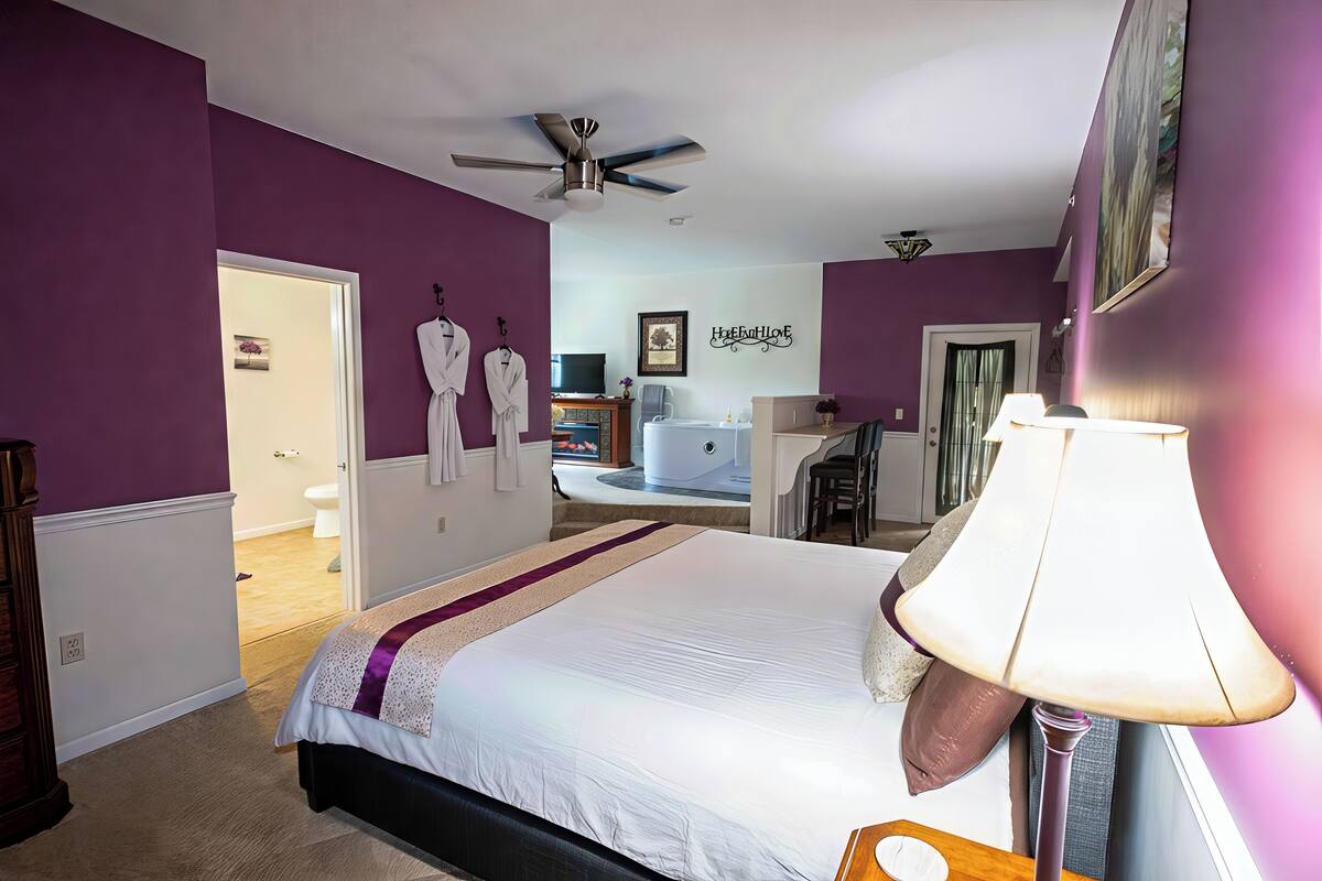 Une chambre à coucher avec un lit, un ventilateur de plafond, un bureau et une chaise.