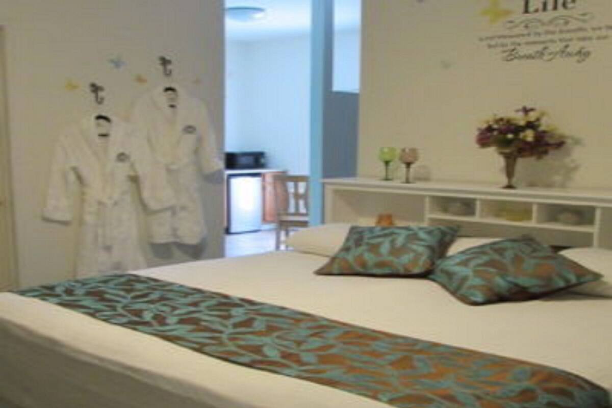 Une chambre d’hôtel avec un lit, des oreillers, une table de chevet et un mur orné d ’un panneau décoratif.