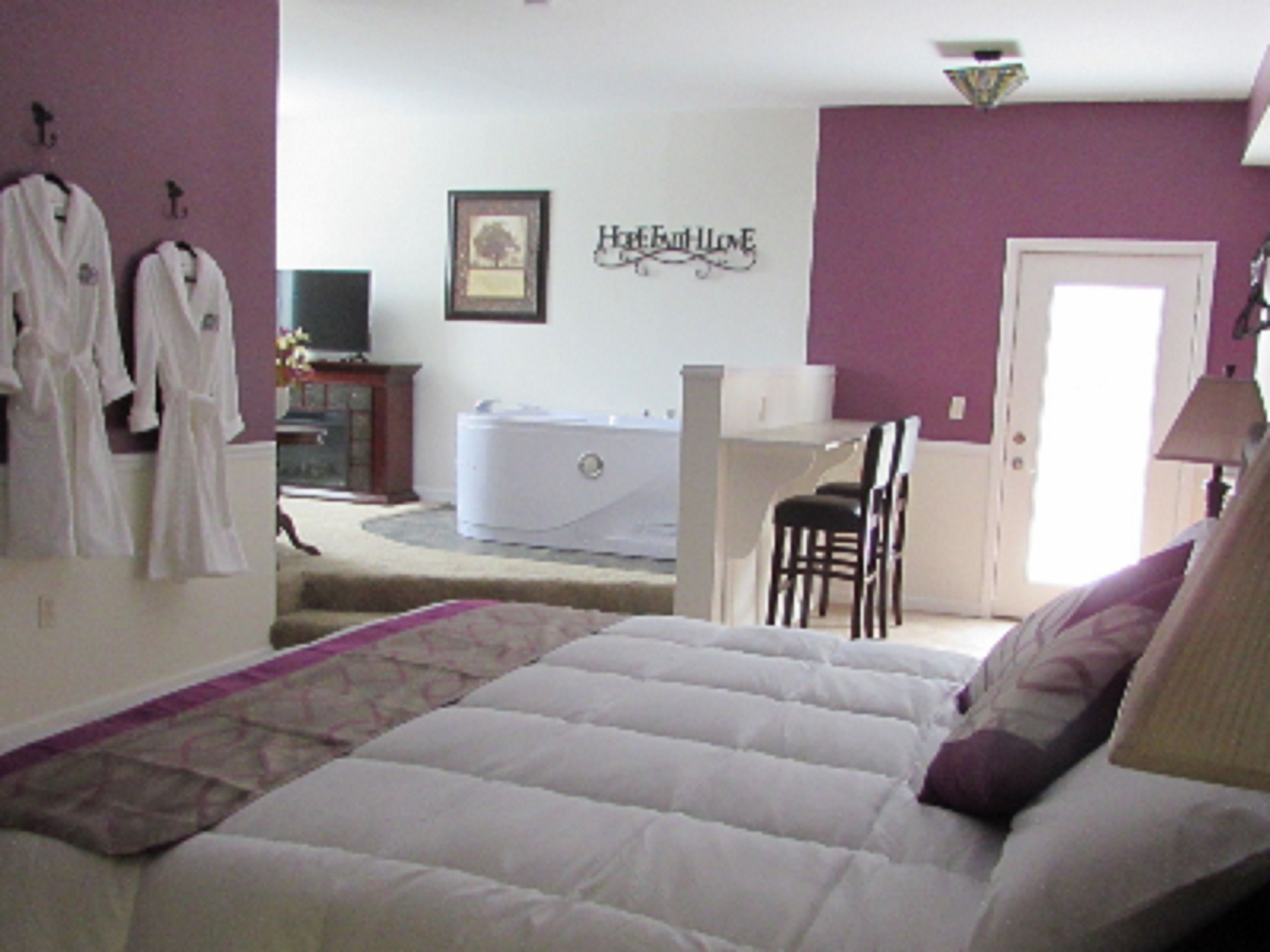 Une chambre à coucher avec un lit, une chaise, un bureau et une baignoire.