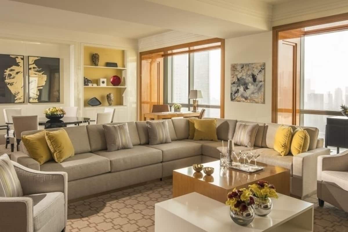 Una sala de estar moderna con un sofá seccional, una mesa de centro y un comedor con una mesa y sillas.