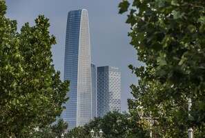 Un rascacielos alto y moderno con un techo curvo y un edificio más bajo con fachada de entramado.