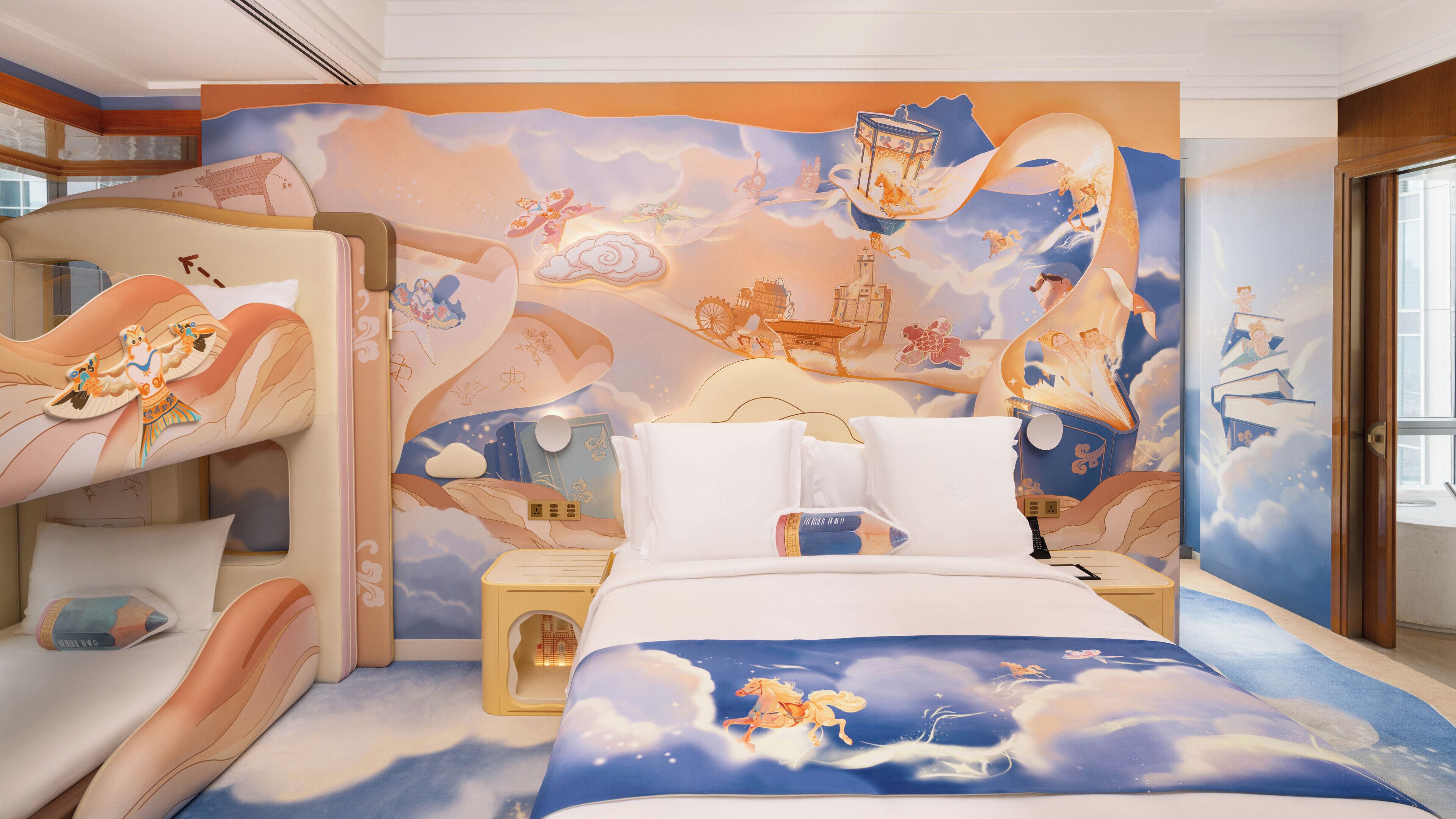 A child's bunk bed with a mural of flying horses and clouds, a bedside table with a book, and a window with a view of the sky.
