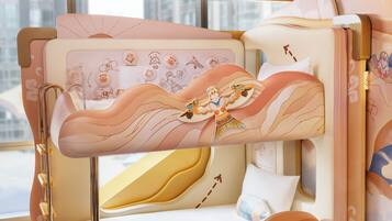 Una cama litera con cabecera y piecera decorativos, una ventana con vistas, y una cama con una colcha estampada.