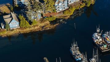 An aerial view of a waterfront property with multiple buildings and a marina with various boats.