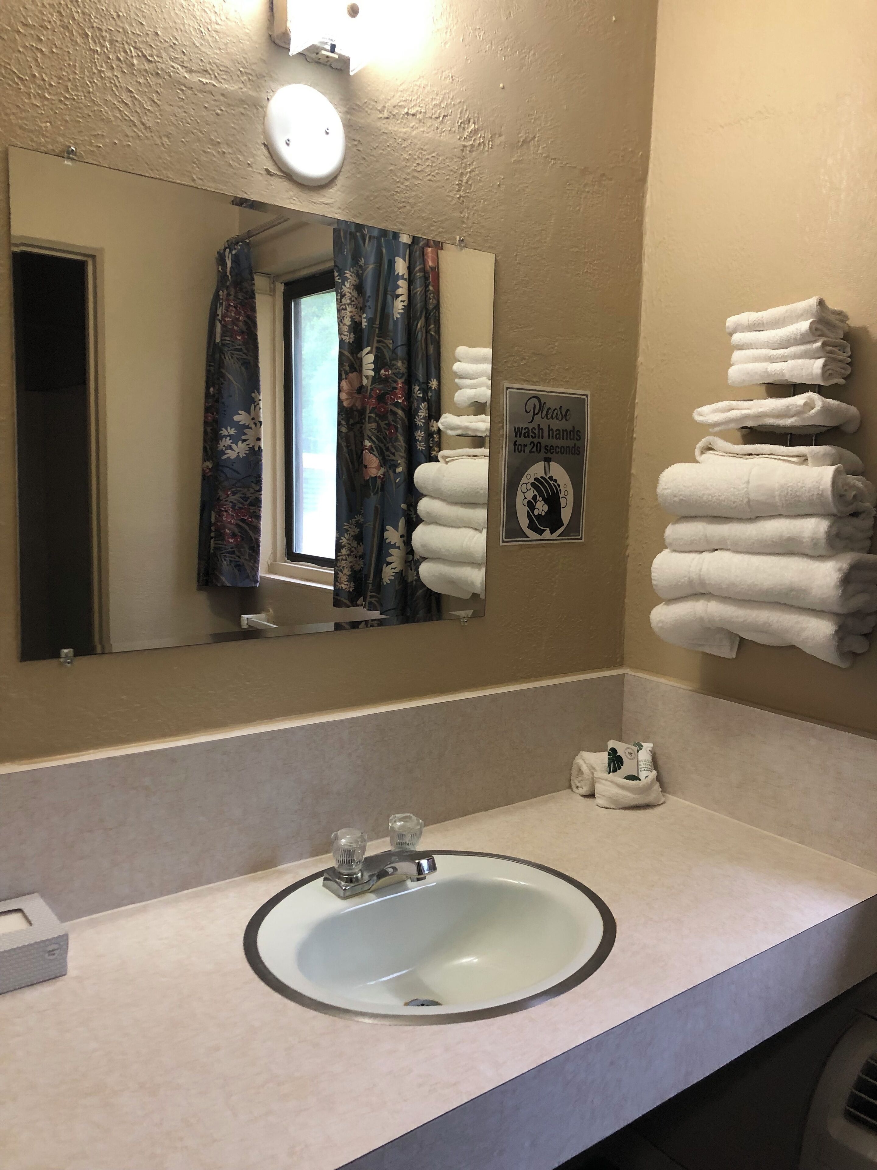 Une salle de bain avec un lavabo, un miroir et des serviettes.