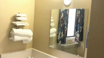 A bathroom with a sink, mirror, and towel rack.