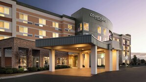 A Courtyard by Marriott hotel with a modern design, featuring a covered entrance and multiple floors.