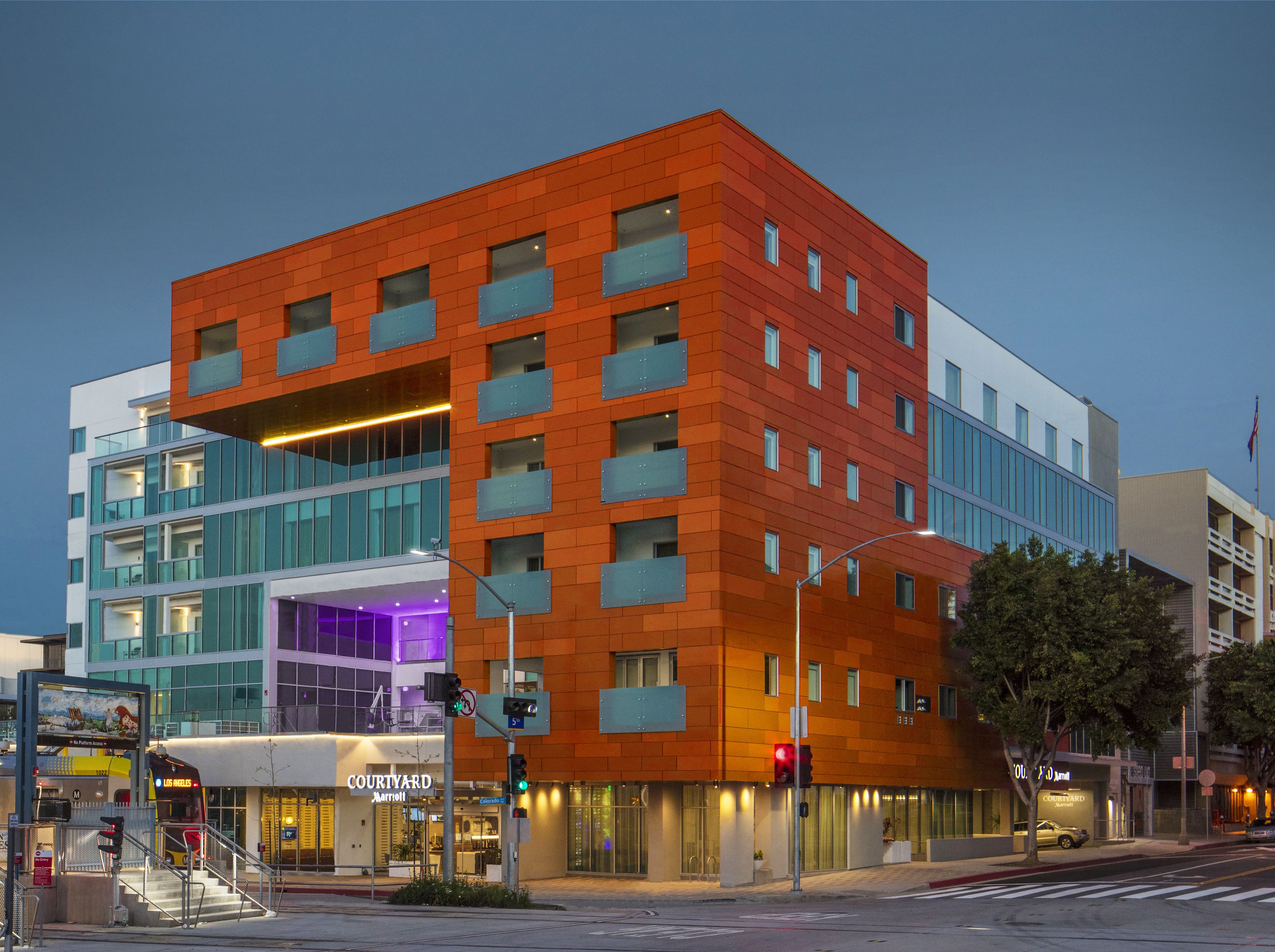 A multi-story hotel with a modern design, featuring a mix of glass and brick facades.