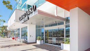 A Courtyard Marriott hotel entrance with a modern design, large glass windows, and outdoor seating area. - Courtyard by Marriott Santa Monica (Santa Monica)