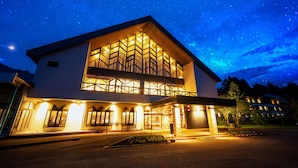 A modern hotel with a large central atrium, multiple balconies, and a well-lit entrance.