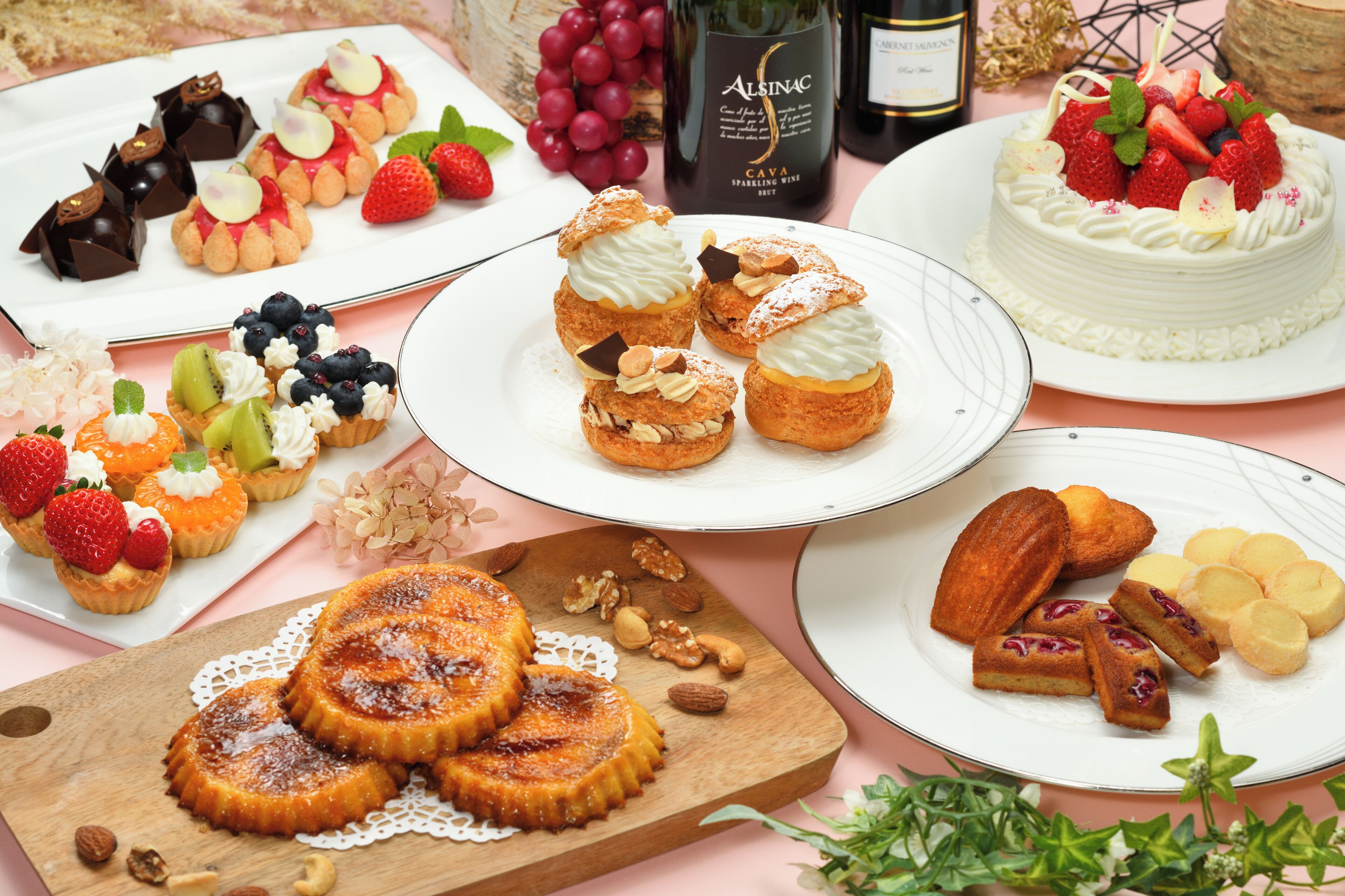 Diverse desserts, waaronder taarten, gebak en fruitgebakjes, op een tafel.