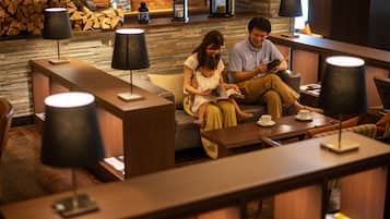 A cozy lounge area with seating, tables, and lamps.