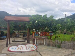 A sign for The Pai Resort with a rustic wooden fence and lush greenery in the background. - The Pai Resort (Pai)