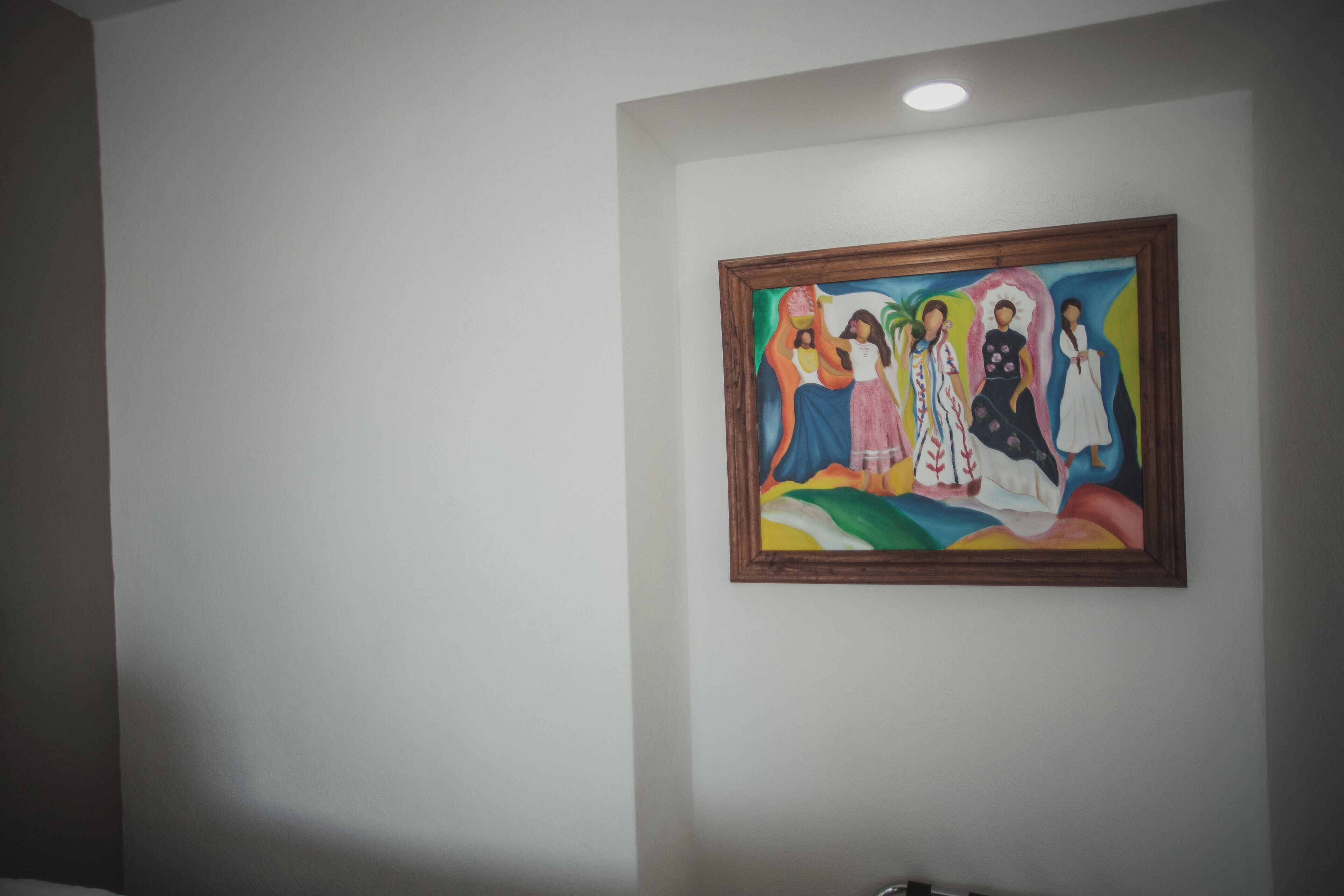 A framed painting on a plain wall.