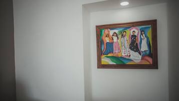 A framed painting on a plain wall.
