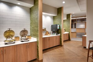 Une cuisine moderne avec des meubles en bois, un plan de travail blanc et un téléviseur encastré.