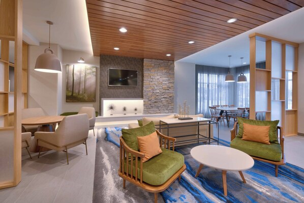 A modern interior with wooden furniture, a stone accent wall, and a large window. - Fairfield Inn & Suites Rockport (Rockport)