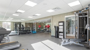 A gym with treadmills, weight machines, and exercise balls.