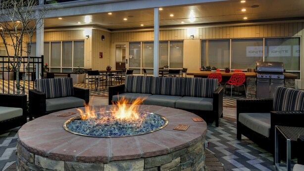 An outdoor seating area with a fire pit, cushioned seating, and a grill. - TownePlace Suites by Marriott McAllen Edinburg (Edinburg)