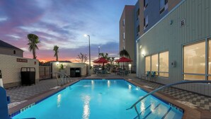 A swimming pool with a tiled edge, a 'No Diving' sign, and outdoor seating with umbrellas. - TownePlace Suites by Marriott McAllen Edinburg (Edinburg)