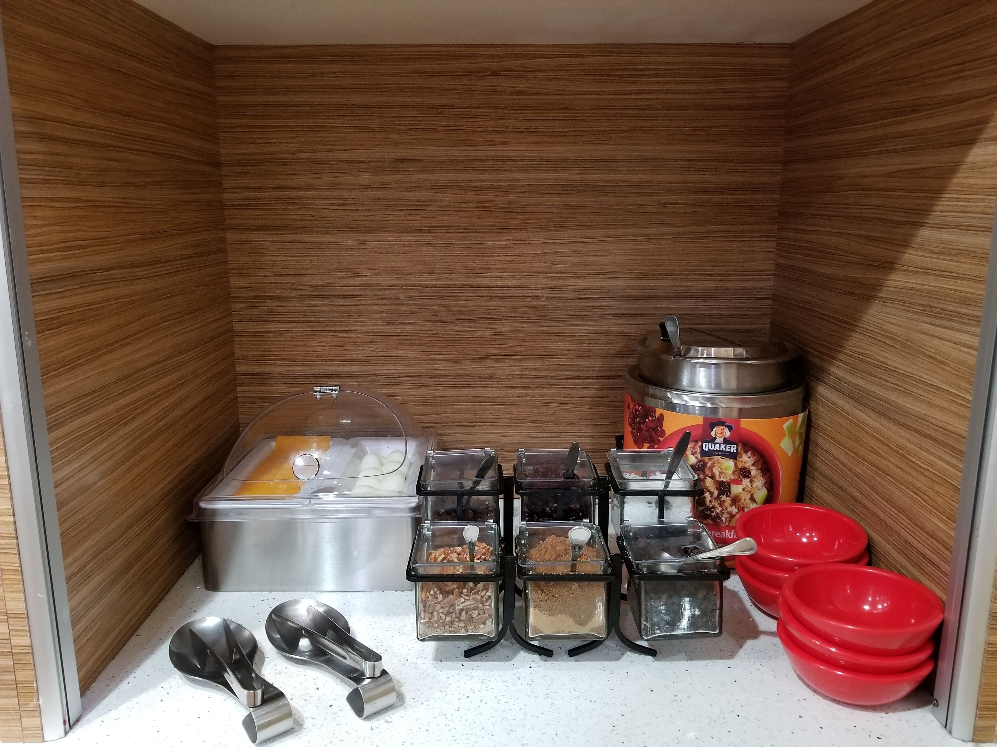 A small kitchenette with a food dispenser, sugar containers, and a Quaker Oats container.