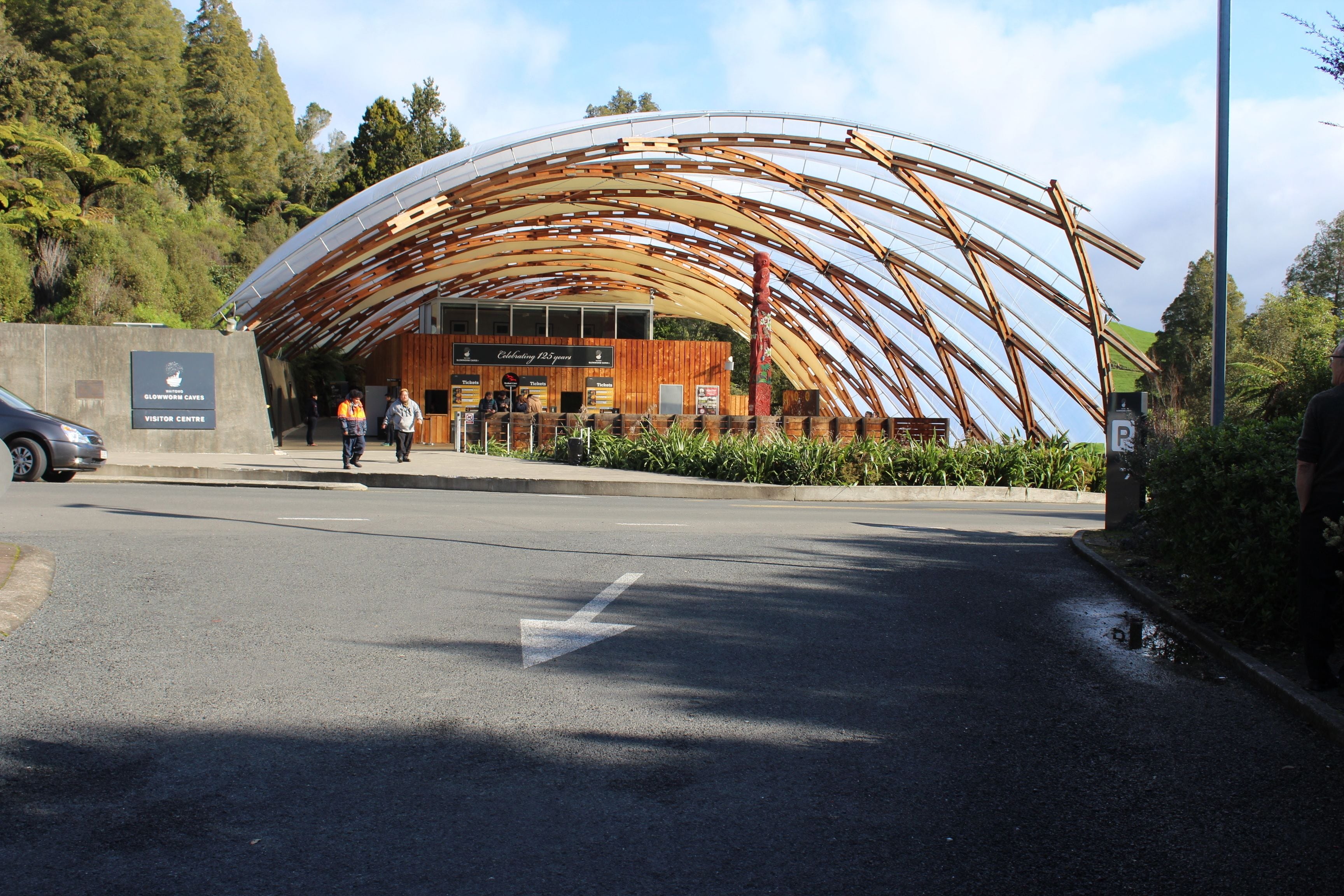 A modern building with a curved wooden roof structure.